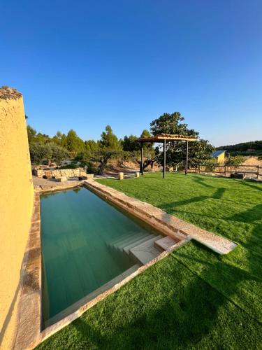 a swimming pool in the middle of a grass field at Serra de Martines in Batea