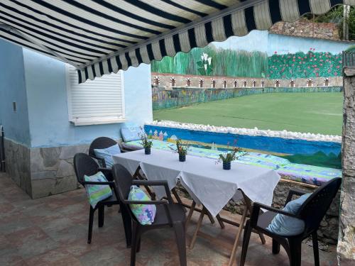 a table with chairs and a tennis court at Vistalegre78 in Grado