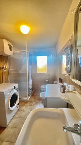 a bathroom with two sinks and a washing machine at Appartamento Torre 82 in Torre Dei Corsari