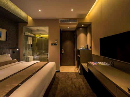a hotel room with a bed and a flat screen tv at Best Western Plus Maple Leaf in Dhaka