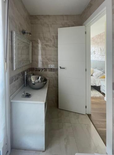 a bathroom with a sink and a mirror and a door at Vistalegre78 in Grado