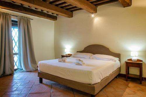 a bedroom with a large white bed with two lamps at Villaluce Wine Agriturismo in Castiglione del Lago