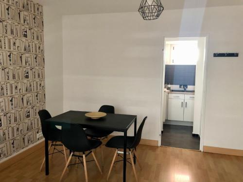 une salle à manger avec une table et des chaises noires dans l'établissement Centre ville avec garage - 4 personnes - Golbery, à Colmar