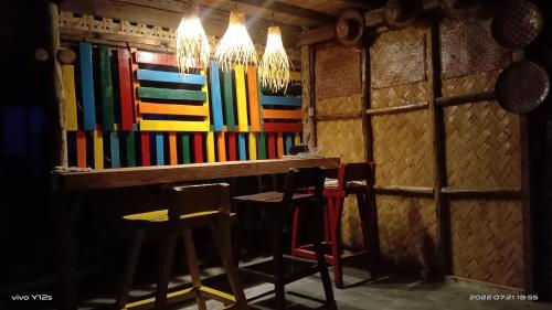 a bar with chairs and a table in a room at Prince John Beachfront Eco Bungalows and Restaurant in San Vicente