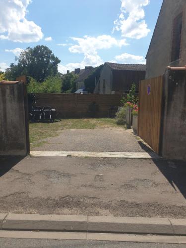 an entrance to a yard with a wooden fence at LE RELAX in Lurcy-Lévis