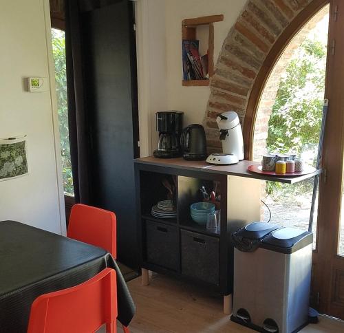 une cuisine avec une table et un comptoir avec un comptoir dans l'établissement Le Merle Rose, à Toulouse
