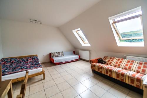 a attic room with two beds and a couch at Apartmán u lesa in Klobouky u Brna