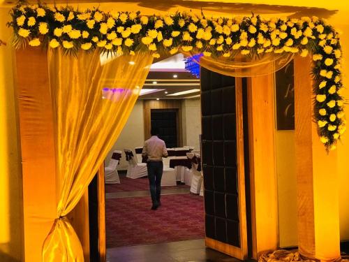 a man walking through a room with a wedding arch with flowers at Ana Clarks Inn, Panchkula in Panchkula