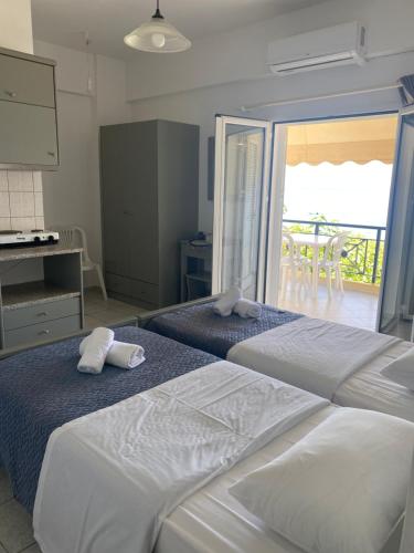 2 łóżka w pokoju hotelowym z balkonem w obiekcie Sindonia beach Apartment's w mieście Psari Forada