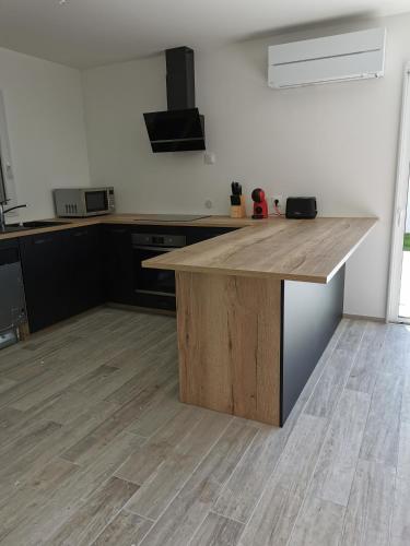 a kitchen with a wooden counter top in a room at Maison Proche Centre Ville in Biscarrosse