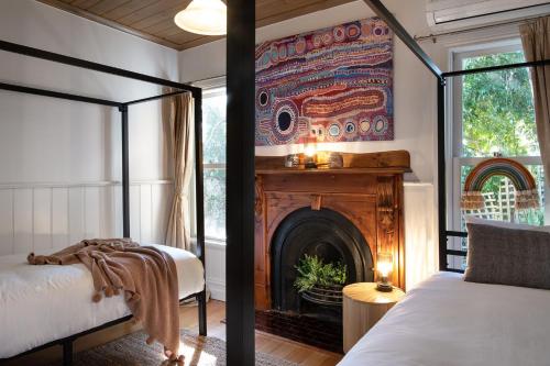 a bedroom with two beds and a fireplace at Ravenswood in Daylesford