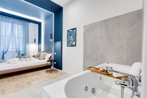 1 dormitorio con 1 cama y baño con bañera. en COLLINA 24 SUITES - close to VIA VENETO, en Roma
