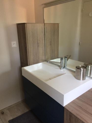 une salle de bain avec un lavabo blanc et un miroir dans l'établissement Villa les Chardons, à La Baule-les-Pins