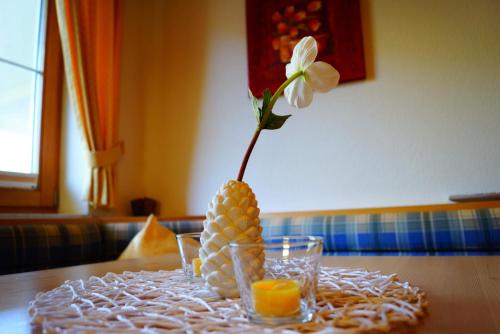a vase with a flower in it on a table at Appartementhaus Olympia Schlössl in Neustift im Stubaital