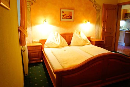 a bedroom with a bed with white sheets and pillows at Appartementhaus Olympia Schlössl in Neustift im Stubaital
