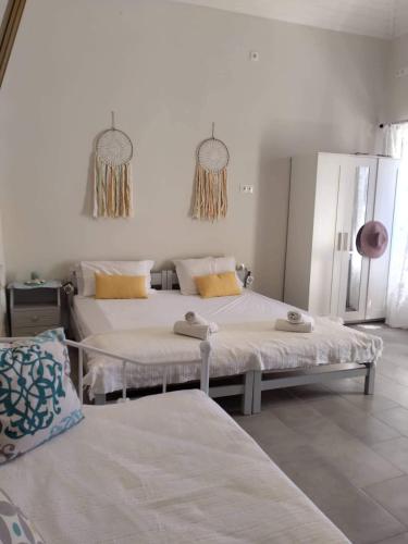 two beds in a white room with two beds at Casa Con Vista Apartments in Halki