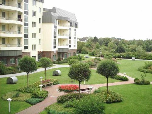 een park met banken en bomen en een gebouw bij Kurparkresidenz in Cuxhaven