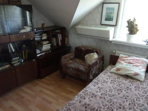 a bedroom with a bed and a chair and a window at Apartment in Kauguri in Jūrmala