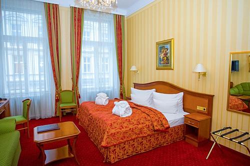 Una habitación de hotel con una cama con dos toallas. en OPERA Am Operneck SELF CHECK IN, en Viena