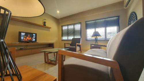 a living room with a tv and a couch and a table at Gold Coast Morib Themepark View Studio in Banting