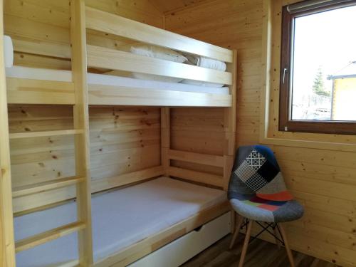 a cabin with a bunk bed and a chair at Domki Na Stoku Laworty in Ustrzyki Dolne