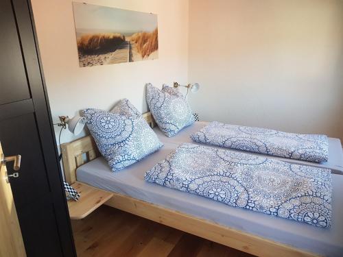 1 dormitorio con 2 camas y almohadas azules en Lamm - Wohnung 3, en Spiegelberg
