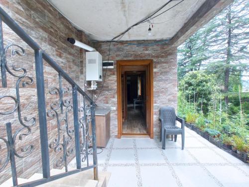 a brick house with a wooden door and a chair at Georgy's Holiday House in Batumi