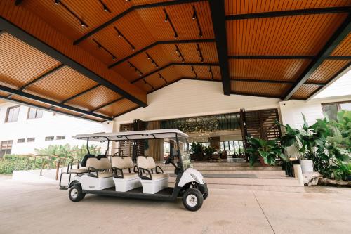 un carro de golf estacionado frente a un edificio en Nouveau Resort en Mambajao