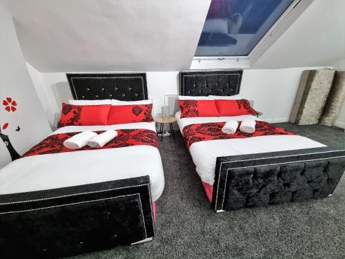 two beds in a room with red pillows at *11BR* Setup for your most amazing relaxed stay + Free Parking + Free Fast WiFi * in Beeston