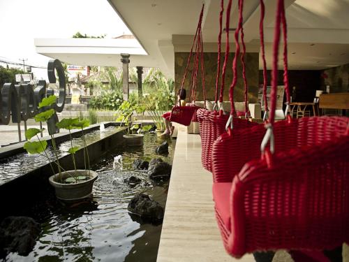 a group of red baskets hanging over a pond at Grand Zuri Kuta Bali in Kuta