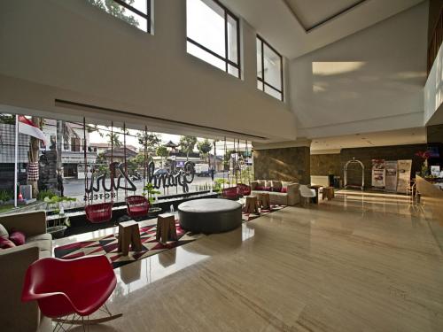 a lobby with red chairs and a large window at Grand Zuri Kuta Bali in Kuta