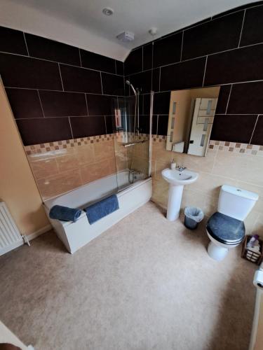 a bathroom with a tub and a toilet and a sink at Entire town house with free parking in Oswestry