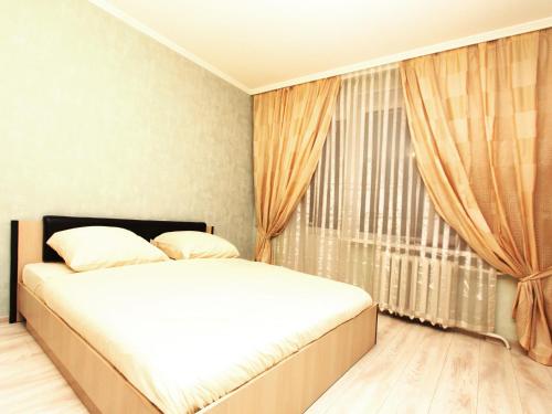 a bedroom with a bed and a large window at ApartLux Arbatskaya in Moscow