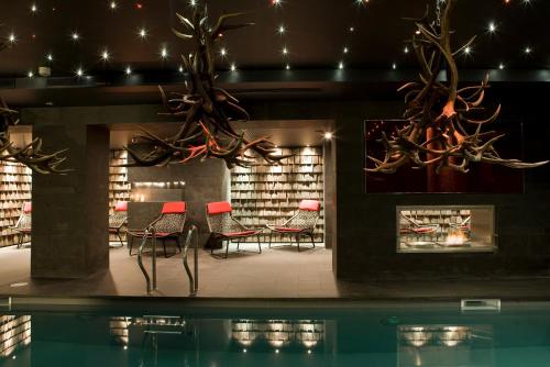 une chambre avec des chaises, une table et une cheminée dans l'établissement Avenue Lodge Hotel & Spa, à Val dʼIsère