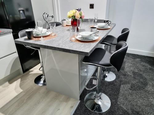 a kitchen with a island with a table with chairs at *11BR* Setup for your most amazing relaxed stay + Free Parking + Free Fast WiFi * in Beeston