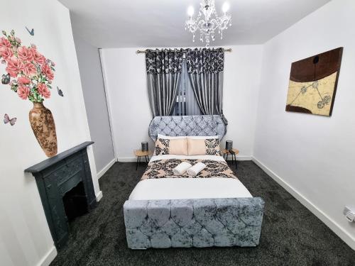 a bedroom with a bed with a chair and a fireplace at *11BR* Setup for your most amazing relaxed stay + Free Parking + Free Fast WiFi * in Beeston