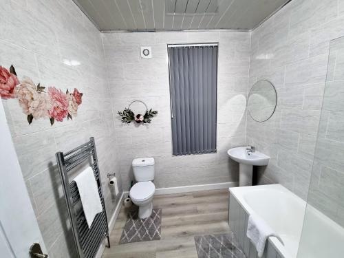 a white bathroom with a toilet and a sink at *11BR* Setup for your most amazing relaxed stay + Free Parking + Free Fast WiFi * in Beeston