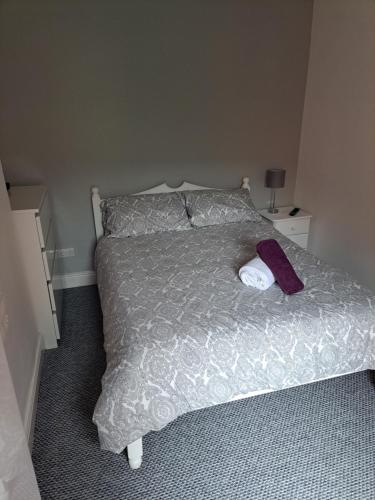 a bedroom with a bed with a purple towel on it at Entire town house with free parking in Oswestry