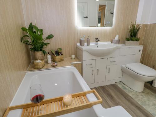 a bathroom with a tub and a toilet and a sink at Columbine Cottage in Ambleside