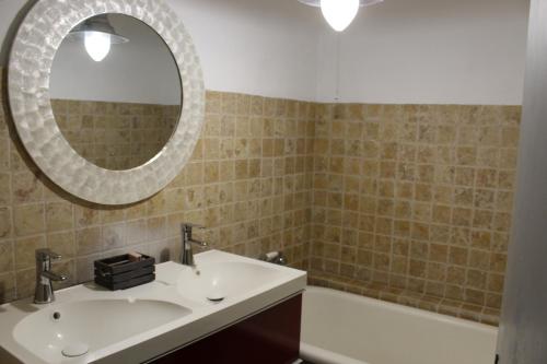 une salle de bain avec un lavabo, un miroir et une baignoire dans l'établissement Maison de ville historique dans la Haute Ville -, à Vaison-la-Romaine