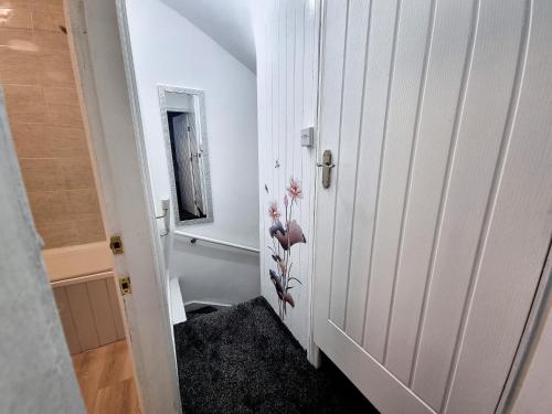 a hallway with a white door and a mirror at *11BR* Setup for your most amazing relaxed stay + Free Parking + Free Fast WiFi * in Beeston