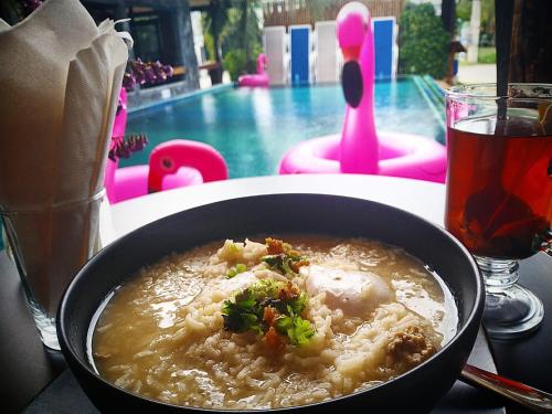 a bowl of food on a table next to a pool at Billabong Hostel in Baan Tai