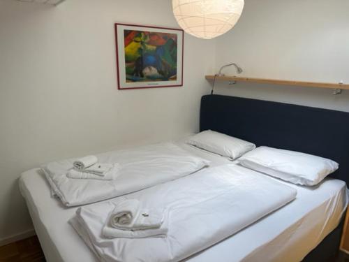 a bed with white sheets and towels on it at Apartment Wendelsteinblick - Wohnen auf Zeit - Homeoffice - Balkon mit Bergblick- buchbar ab 28 Nächte in Schliersee