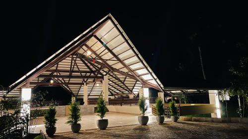 a building with potted plants in front of it at night at Commune18 Resort Chikmagalur in Chikmagalūr