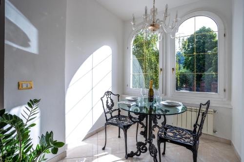 a dining room with a glass table and two chairs at Villa Beatrice 1836 in Cormòns
