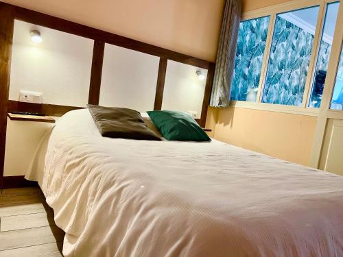 a bedroom with a large white bed with a window at Plage à 50m Appartement Rêves tranquilles Villa Les Bains de Mers in Mers-les-Bains