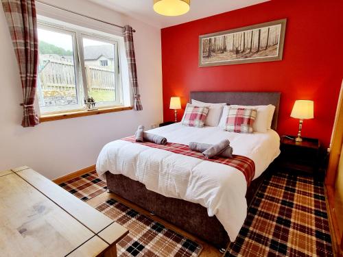 a bedroom with a large bed with red walls at Hill View 2 bedroom in Inverness