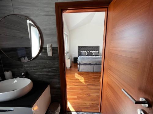 baño con lavabo, espejo y cama en Villa Sanja I, en Trogir