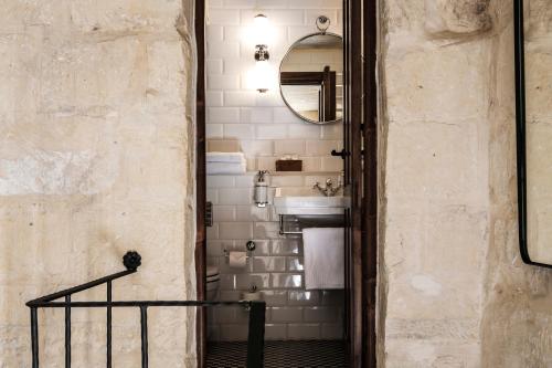 a bathroom with a sink and a mirror at Cesca's Boutique Hotel in Xlendi