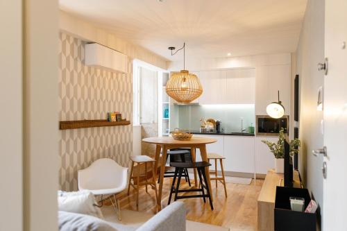 Il comprend une petite cuisine et une salle à manger avec une table et des chaises. dans l'établissement Green Apartment Foz, à Porto